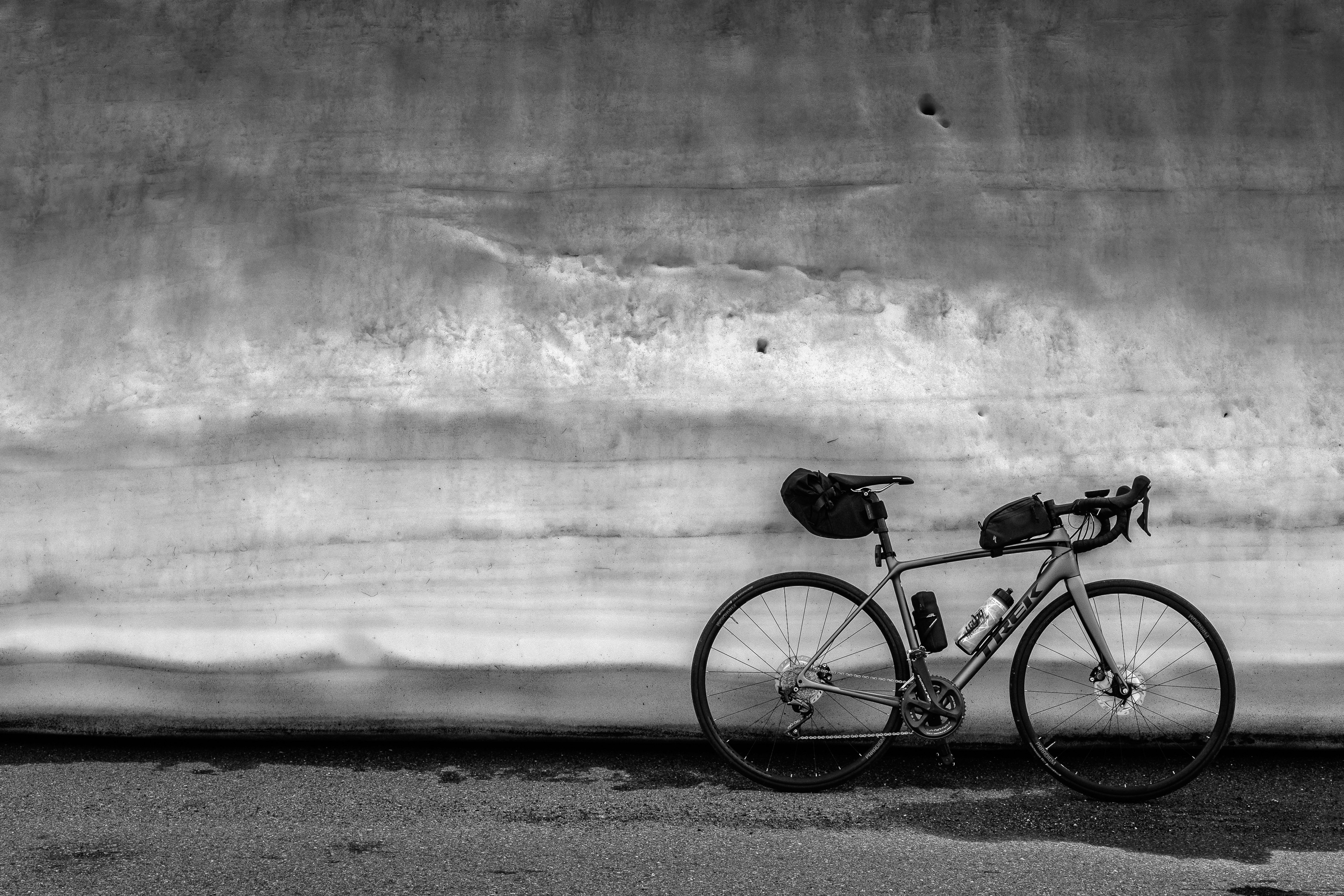 gray bicycle parked beside wall